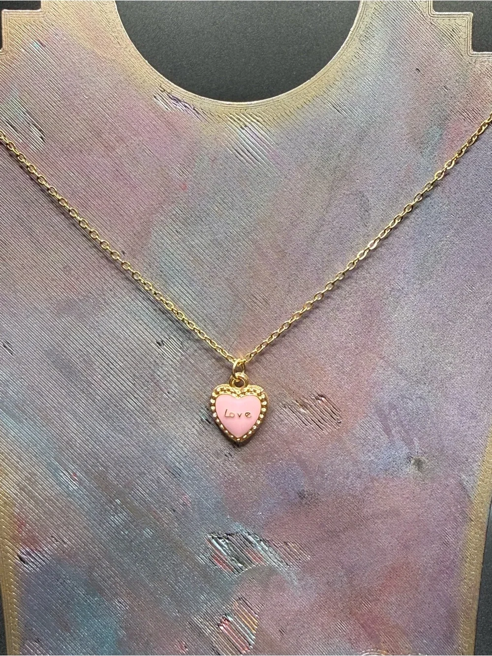 Gold-Tone Necklace with Pink Heart Pendant and bow at the end.